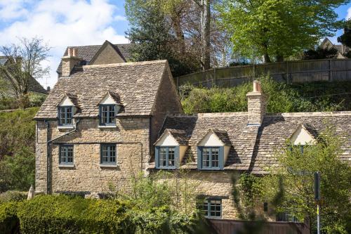 an old stone house with windows on a hill at The Royal Oak Tetbury in Tetbury