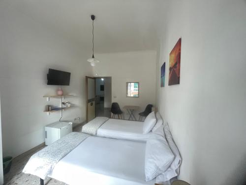 - une chambre avec 2 lits et une table avec des chaises dans l'établissement Casa Amore, à Tarente