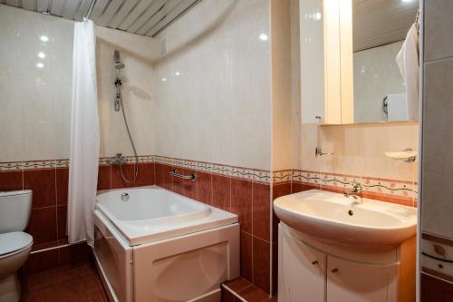 a bathroom with a sink and a toilet and a tub at Historical Hotel Kaluga in Kaluga