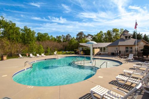 a large swimming pool with chairs and an umbrella at Mountain Retreat Condo View Community Amenities in Pigeon Forge