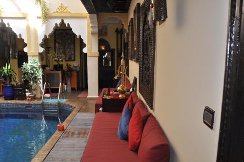 a living room with a couch next to a swimming pool at Riad des Etoiles in Marrakesh