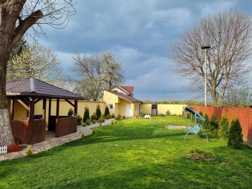 un patio con una valla y una casa en Izabella Guest House, en Săcele