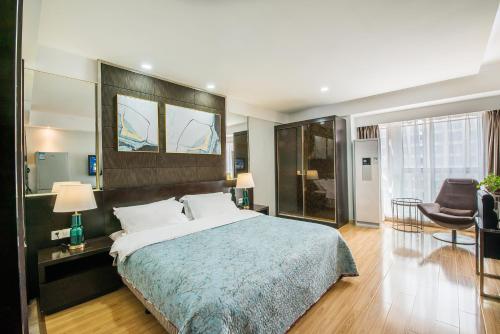 a bedroom with a large bed and a living room at Nanjing Kaibin Apartment - Aishang Shopping Mall in Nanjing
