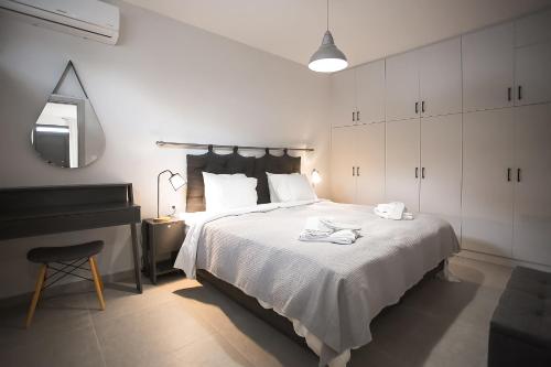 a bedroom with a white bed and a piano at Serenity Suites Corfu in Potamós