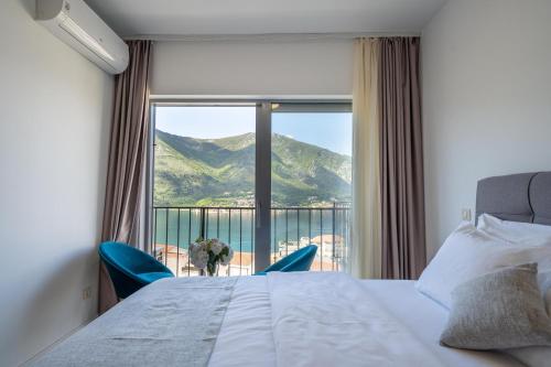 een slaapkamer met een bed en een groot raam bij Andjela's studio in Kotor