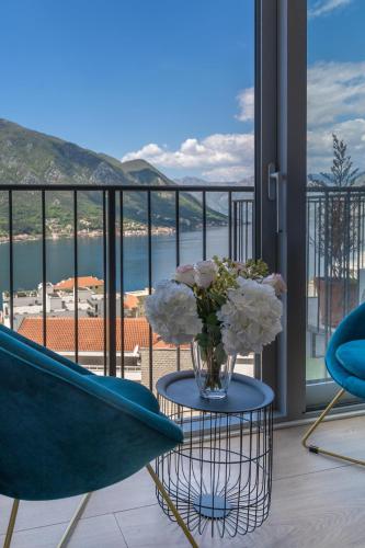 a vase of flowers on a table in front of a balcony at Andjela's Studio in Kotor