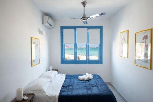 a bedroom with a bed and a window with the beach at Casa Blu sul mare e centralissima in San Vito lo Capo