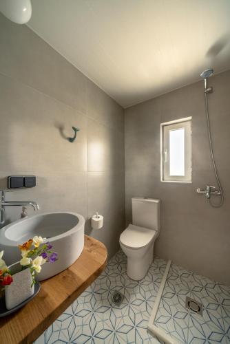 a bathroom with a bath tub and a toilet at Grand Bleu Anastazia in Porto Heli