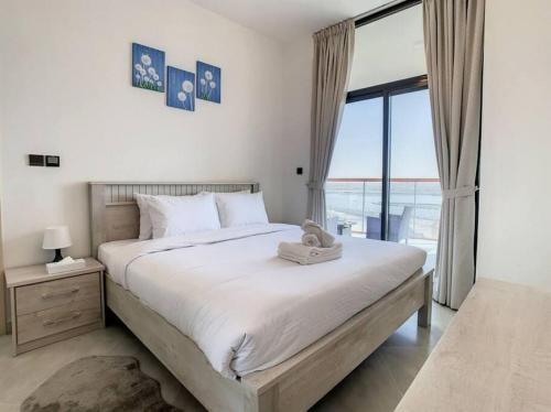 a bedroom with a large bed with a large window at Key View - Binghatti Avenue, Al Jaddaf in Dubai
