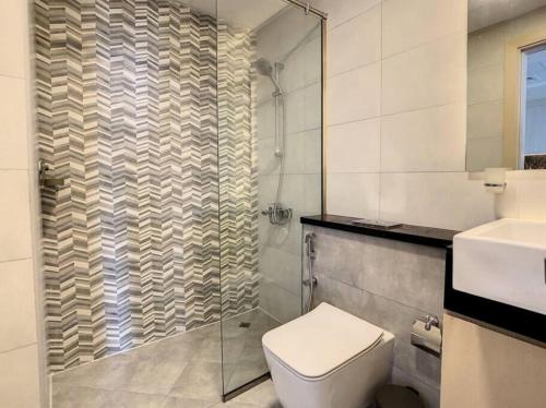 a bathroom with a toilet and a glass shower at Key View - Binghatti Avenue, Al Jaddaf in Dubai