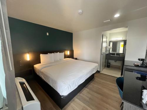 a bedroom with a large bed with a green wall at Suites Escondido CA in Escondido