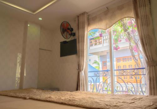 um quarto com uma cama e uma janela com uma varanda em Hotel Hoàng Thịnh em Da Nang