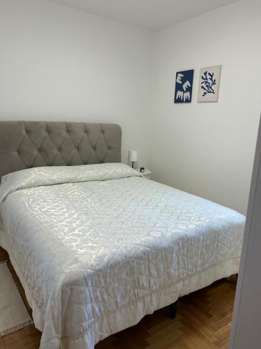 a bedroom with a bed with a white comforter at Zio Nino in Sutomišćica