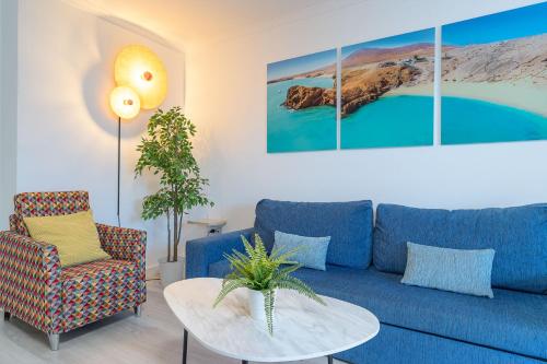 a living room with a blue couch and a table at Rosamar Apartamentos in Puerto del Carmen