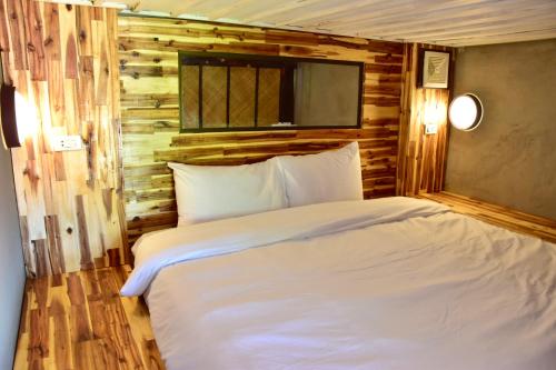 a bed in a room with a wooden wall at Mad Monkey Luang Prabang in Luang Prabang