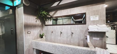 a bathroom with a sink with a mirror and towels at 拉開門輕旅 Le Passage Hostel in Taipei