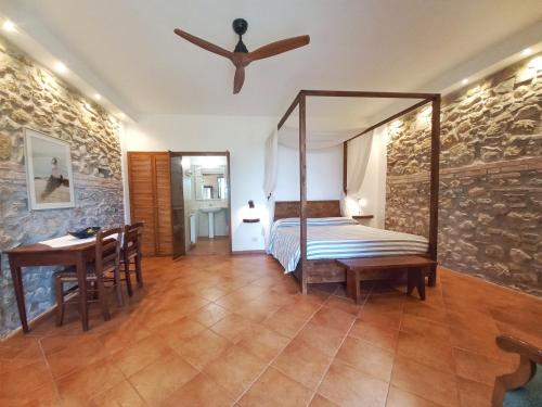 Schlafzimmer mit einem Bett, einem Tisch und einem Deckenventilator in der Unterkunft Celestina- Agriturismo La Valentina in Talamone