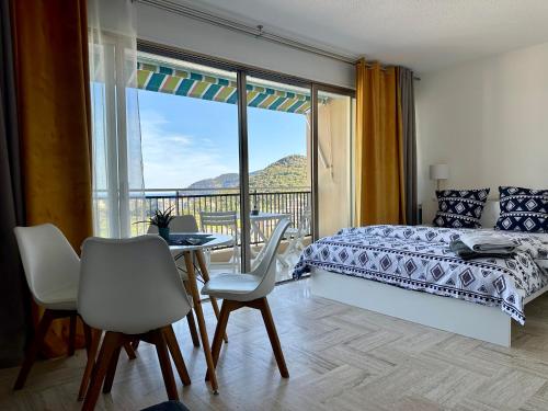 um quarto com uma cama, uma mesa e cadeiras em Cannes Marina vue mer em Mandelieu-la-Napoule