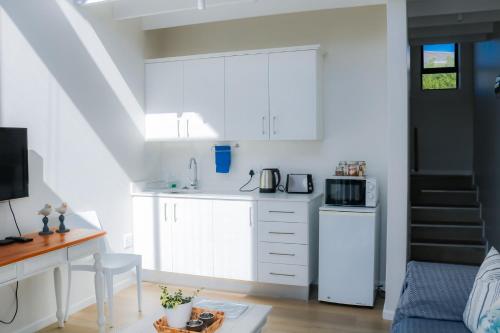 a kitchen with white cabinets and a white refrigerator at Cottage with a View in St Francis Bay