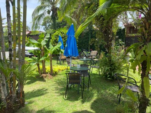 a patio with tables and chairs with blue umbrellas at Posada Nena Caribe in Puerto Viejo