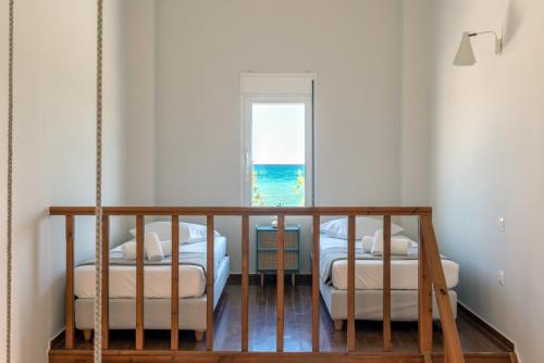 two beds in a room with a view of the ocean at Grand Bleu Anastazia in Porto Heli