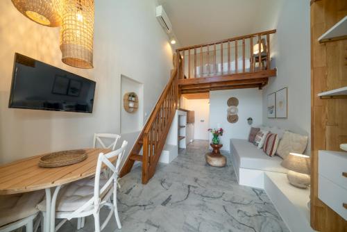 a living room with a staircase and a table and a couch at Grand Bleu Anastazia in Porto Heli