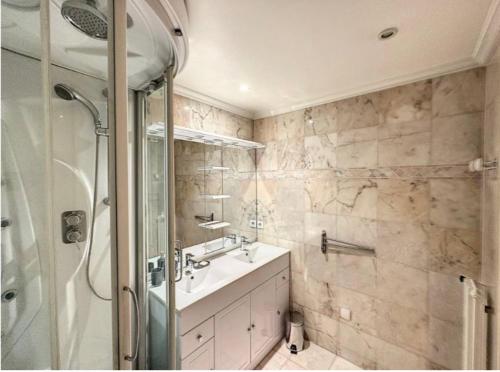 uma casa de banho com uma cabina de duche em vidro e um lavatório. em Mimosas -2 rooms-Terrace-City center -Air conditioning em Cannes
