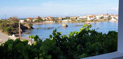 a river with boats in the middle of a town at Sunset Holiday House in Archangelos