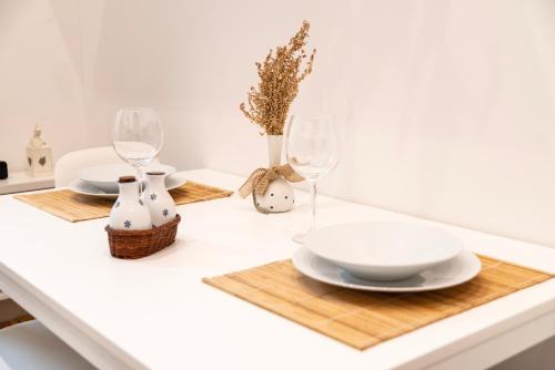 a table with two plates and wine glasses on it at Appartamento nel cuore di Messina in Messina