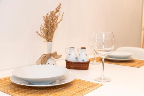 a table with a plate and a glass of wine at Appartamento nel cuore di Messina in Messina