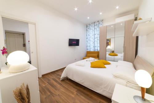 - une chambre blanche avec un lit et un miroir dans l'établissement Appartamento nel cuore di Messina, à Messina