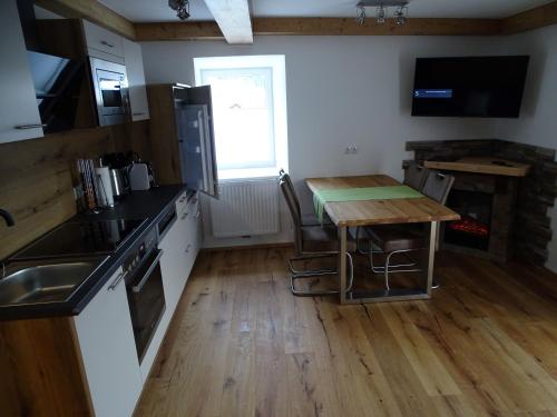 a kitchen with a wooden table and a kitchen with a sink at Altroiterhof in St. Wolfgang