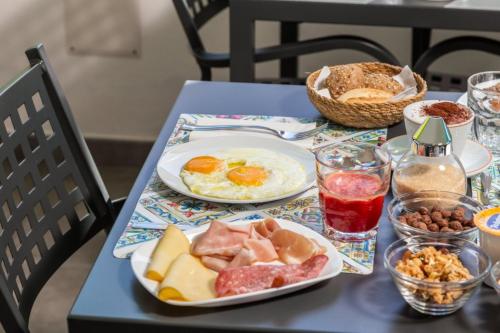 a table with plates of breakfast food on it at L'Essenza Hotel in Olbia