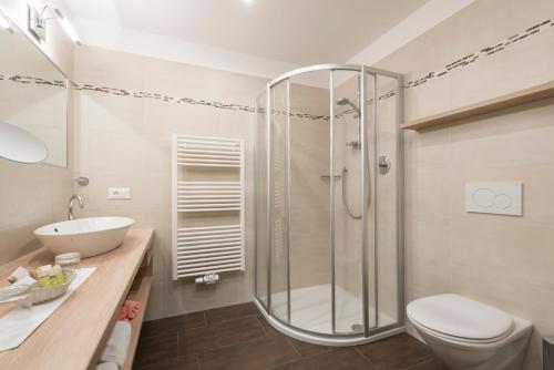 a bathroom with a shower and a toilet and a sink at Hotel Meinhardt in Schenna