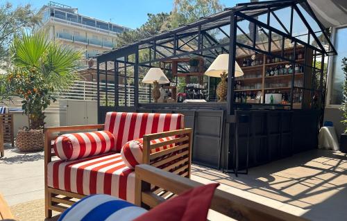 a patio with two chairs and a bar in a building at MARITTIMO Milano Marittima in Milano Marittima