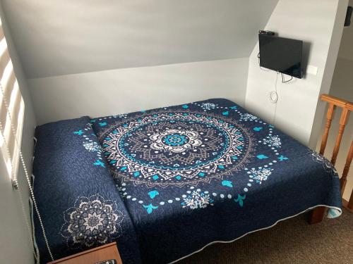 Una cama en una habitación con una manta azul. en Apartamento Estocolmo III, en Valdivia