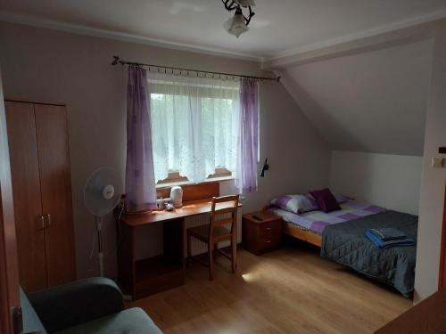 1 dormitorio con escritorio, 1 cama y ventana en Augustów Summer Camp, en Augustów