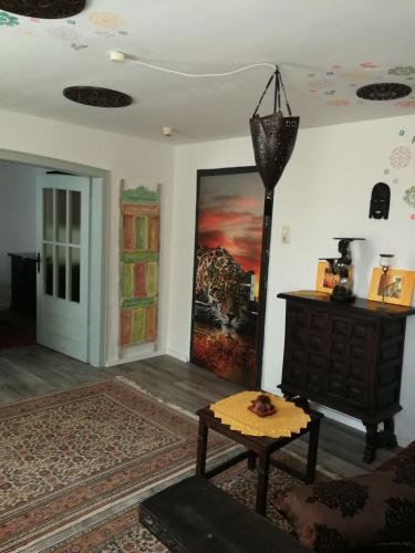 a living room with a table and a painting on the wall at Gästehaus Fuchsröhre in Welcherath