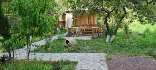 un jardín con una mesa y una casa con árboles en Mirage guesthouse, en Khot
