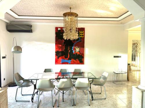 a dining room with a glass table and chairs at APPARTEMENTS NIA CONFORT, Plein centre ville, avec TERRASSE in Fès