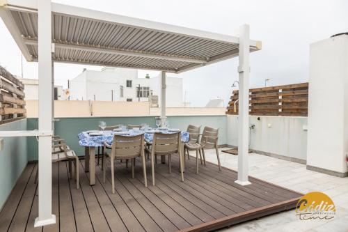 un patio con mesa y sillas en una terraza en Mirador de la Viña Free Parking by Cadiz Time, en Cádiz
