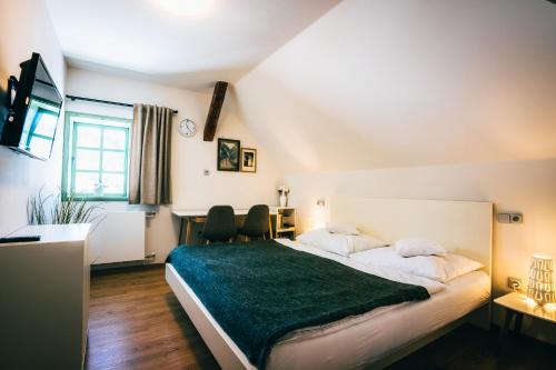 a bedroom with a large bed with a green blanket at Aparthotel & Wellness Knížecí cesta in Horní Planá