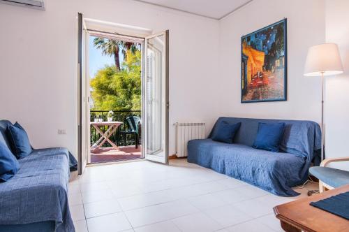 a living room with a couch and a sliding glass door at Ortensia Apartments by Wonderful Italy in Aci Castello