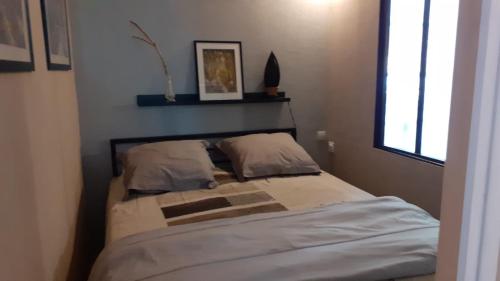 - une chambre avec un lit avec deux oreillers et une fenêtre dans l'établissement CAUTERETS Appartement F 2 vue sur montagne, à Cauterets