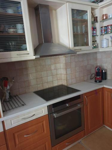 a kitchen with wooden cabinets and a stove top oven at Modern 2BR city flat 10min from the beach in Athens