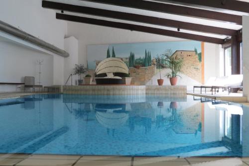 ein großer Pool mit blauem Wasser in einem Gebäude in der Unterkunft Doppelzimmer Allgäuer Stub'n in Oberstaufen