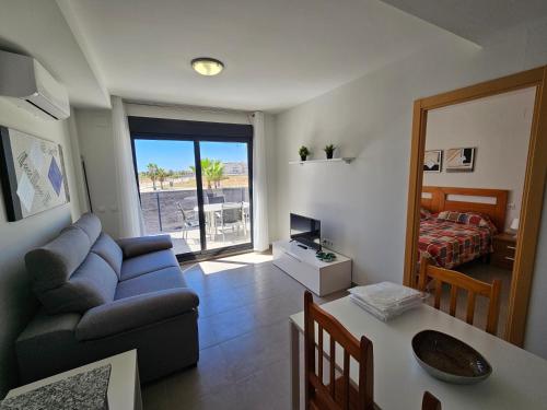 uma sala de estar com um sofá e um quarto com uma cama em Realrent Neo Mediterráneo em Barrio-Mar