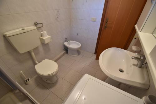 a small bathroom with a toilet and a sink at Bilocale SABBIA 3 - Zona mare con terrazza, clima e posta auto in Marina di Campo