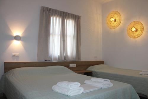 a hotel room with two beds with towels on them at Eleftheria Studios in Balíon