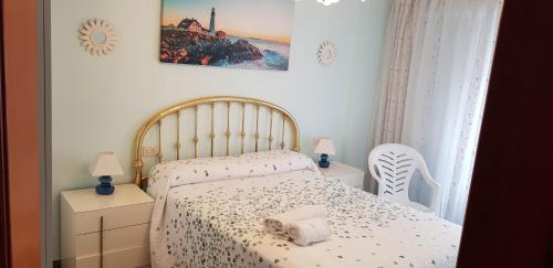 Un dormitorio con una cama con una toalla encima. en Apartamento Sol y Playa, en Puerto Sagunto